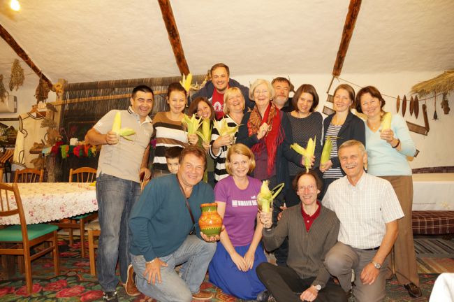 Field Group attendants holding corn cobs (corn is a traditional dish in Moldova)